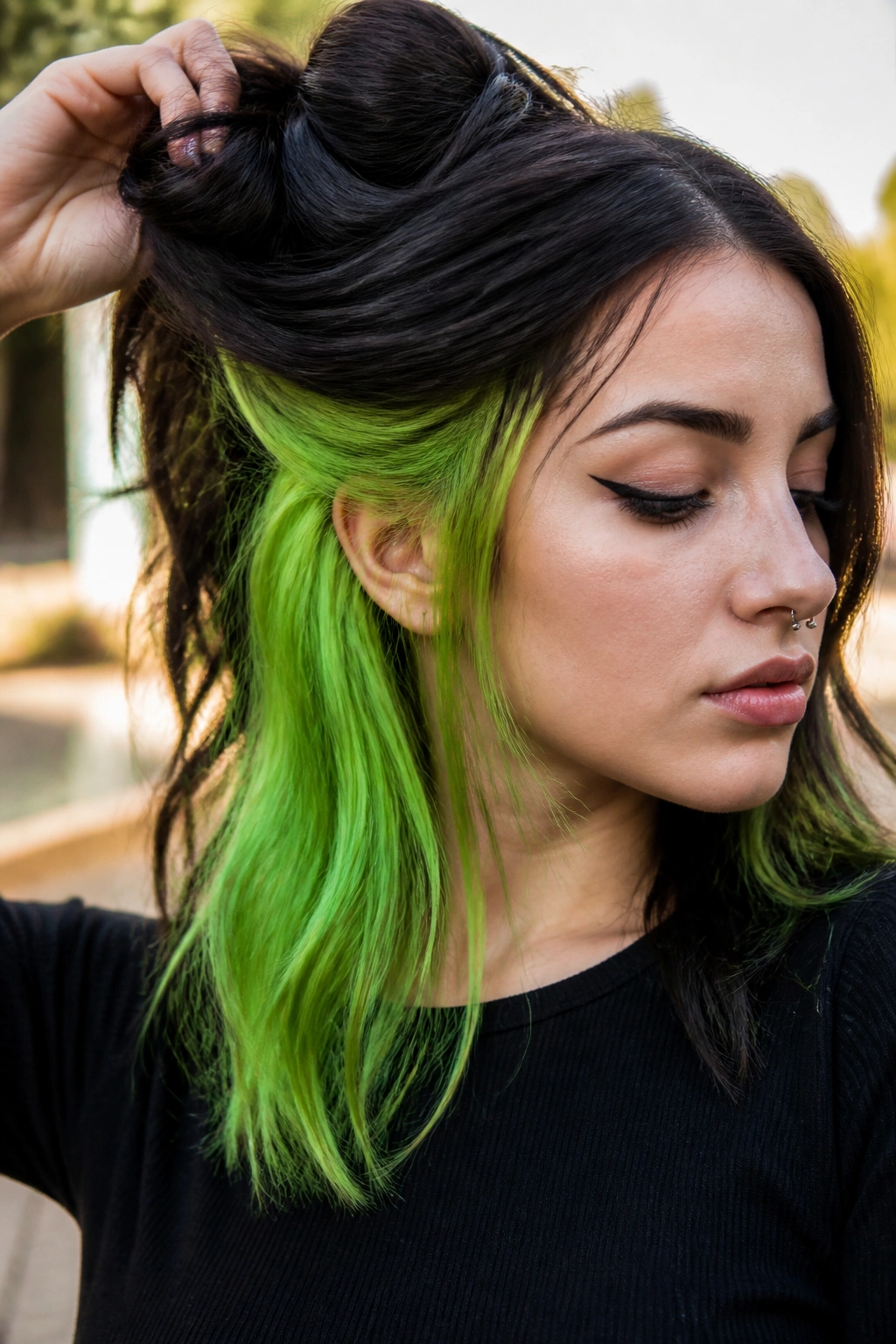 Close-up portrait of a real person with candy green underlights peeking through dark hair