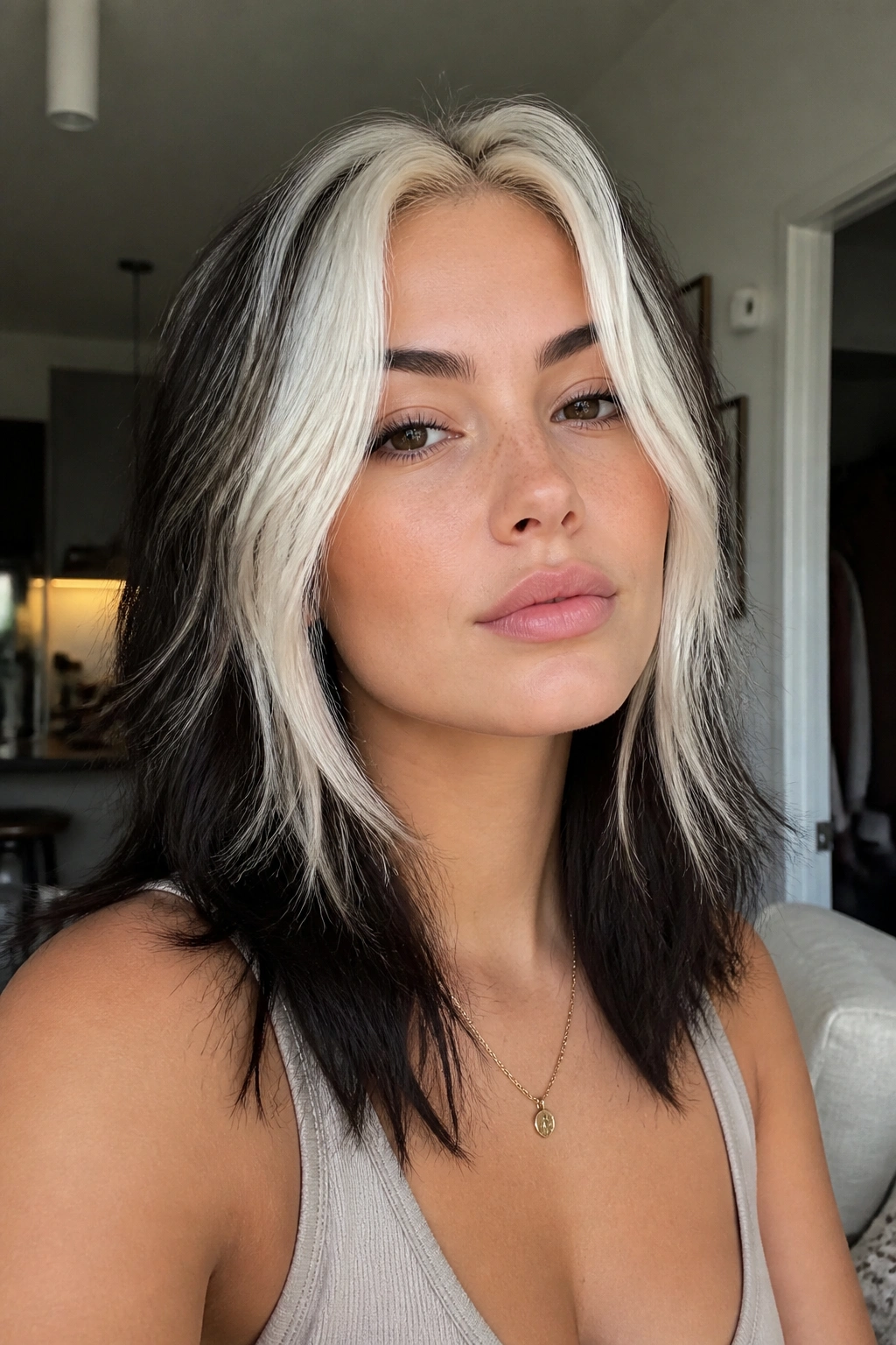 Close-up portrait of a real woman with platinum money-piece wolf cut and darker back.
