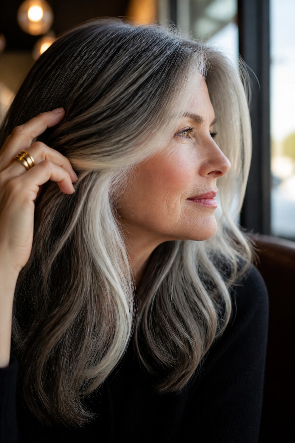 Close-up of a real woman with platinum peekaboo panels under the top hair layer in a sunlit setting