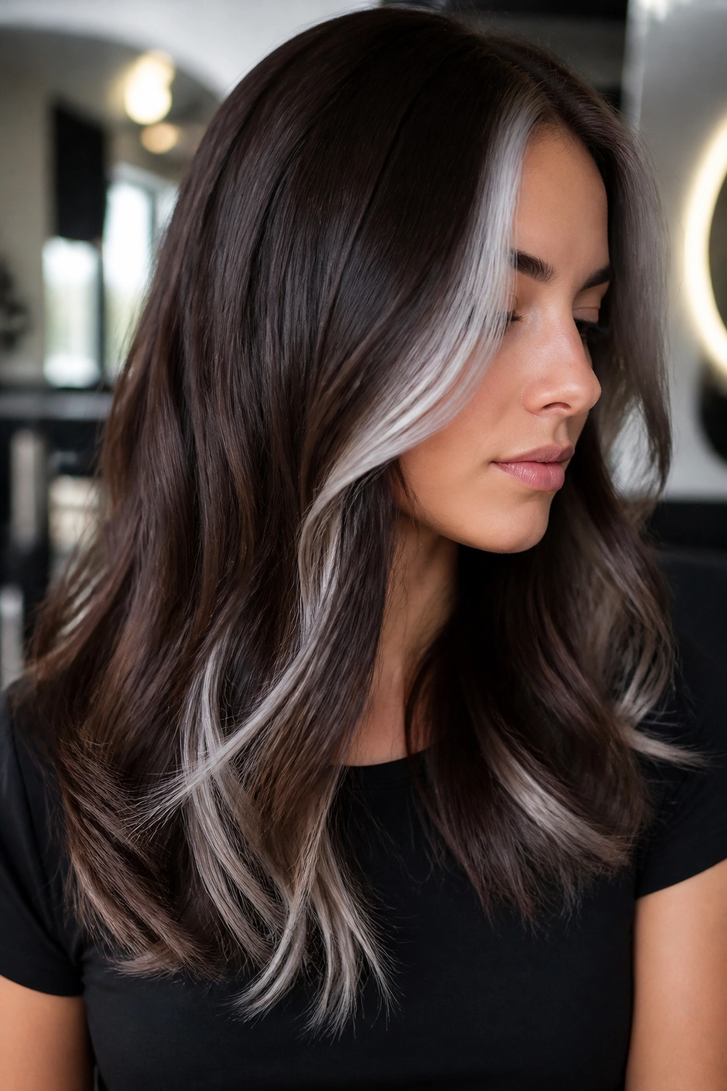 Close-up of dark brown hair with platinum-silver accent pieces near the face