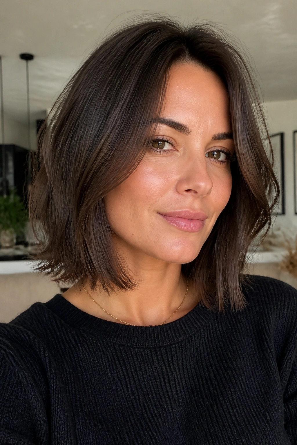 Close-up of a real person with a razor-cut lob and reduced internal weight in a modern apartment.