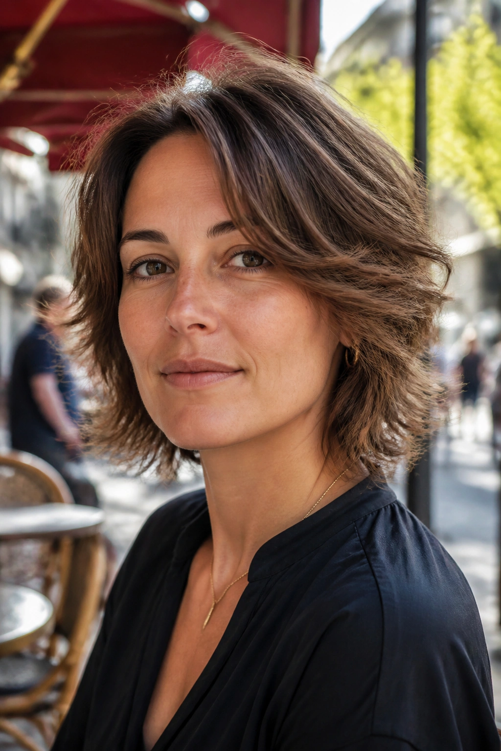 Close-up of a real person with a razor-shaped shag without fringe in outdoor cafe