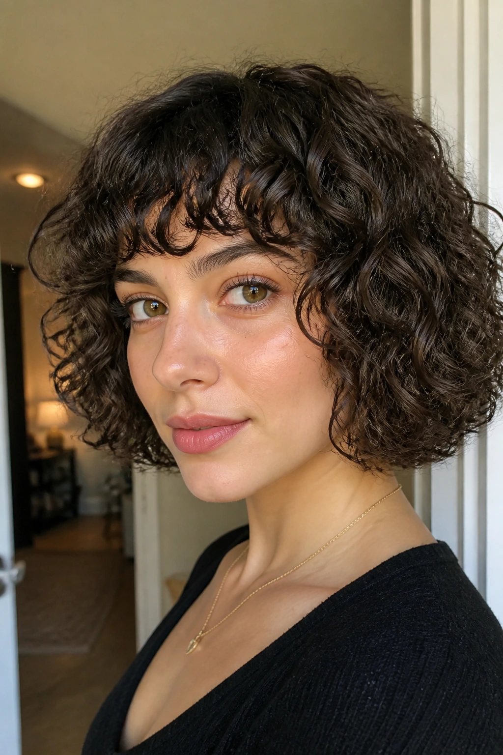 Close-up of a real woman with a jaw-length ringlet bob and eyebrow-skimming bangs