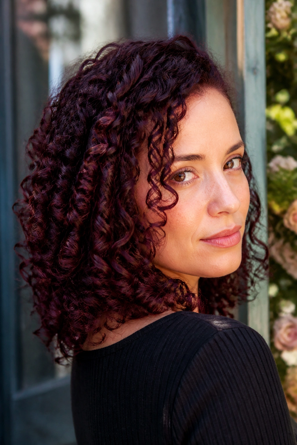 Close-up of a woman with blackberry ringlets and deep purple-red color