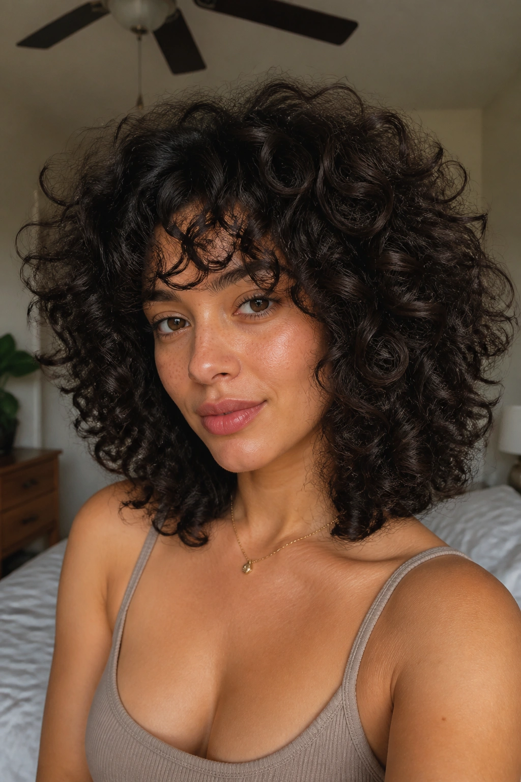 Real woman with rounded shag on thick curls in soft morning light