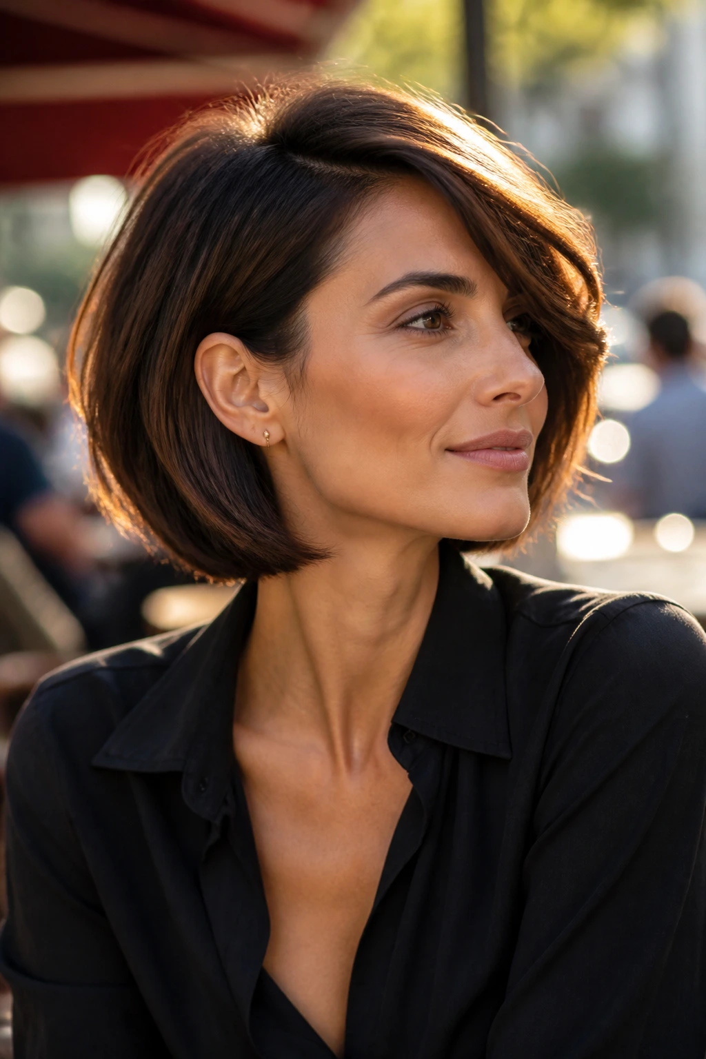 Side-swept Italian bob highlighting cheekbone lift on a real woman outdoors.
