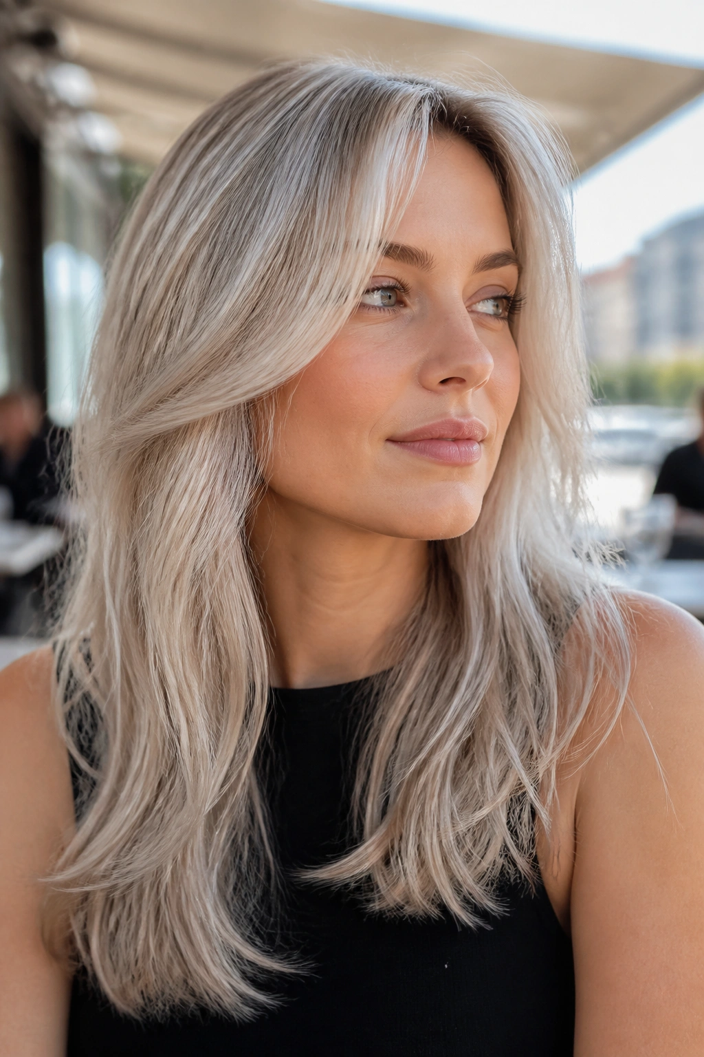 Portrait of a woman with silver champagne blonde hair catching soft outdoor light.