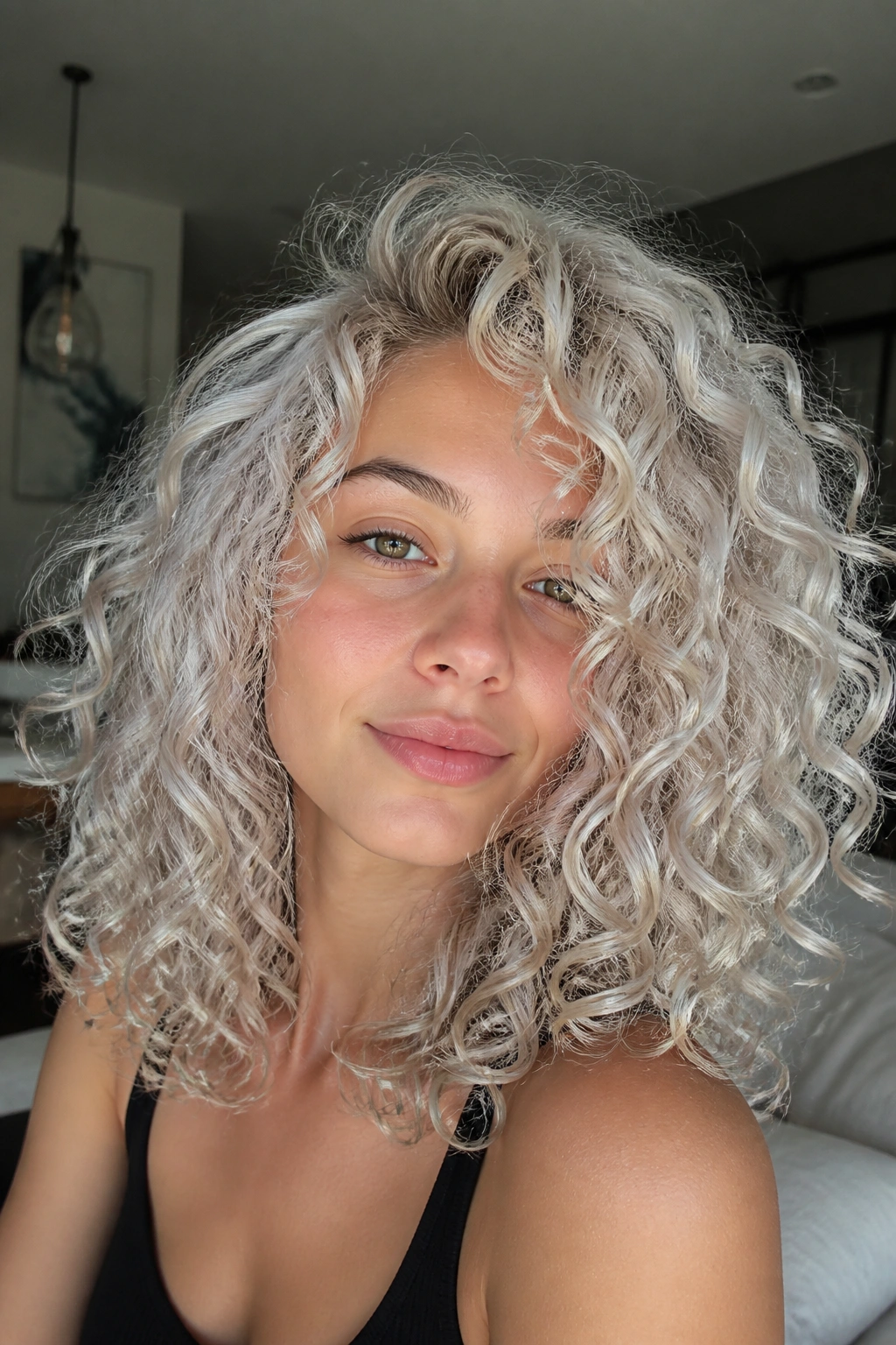 Real person with silver-platinum curls catching light in a cozy room