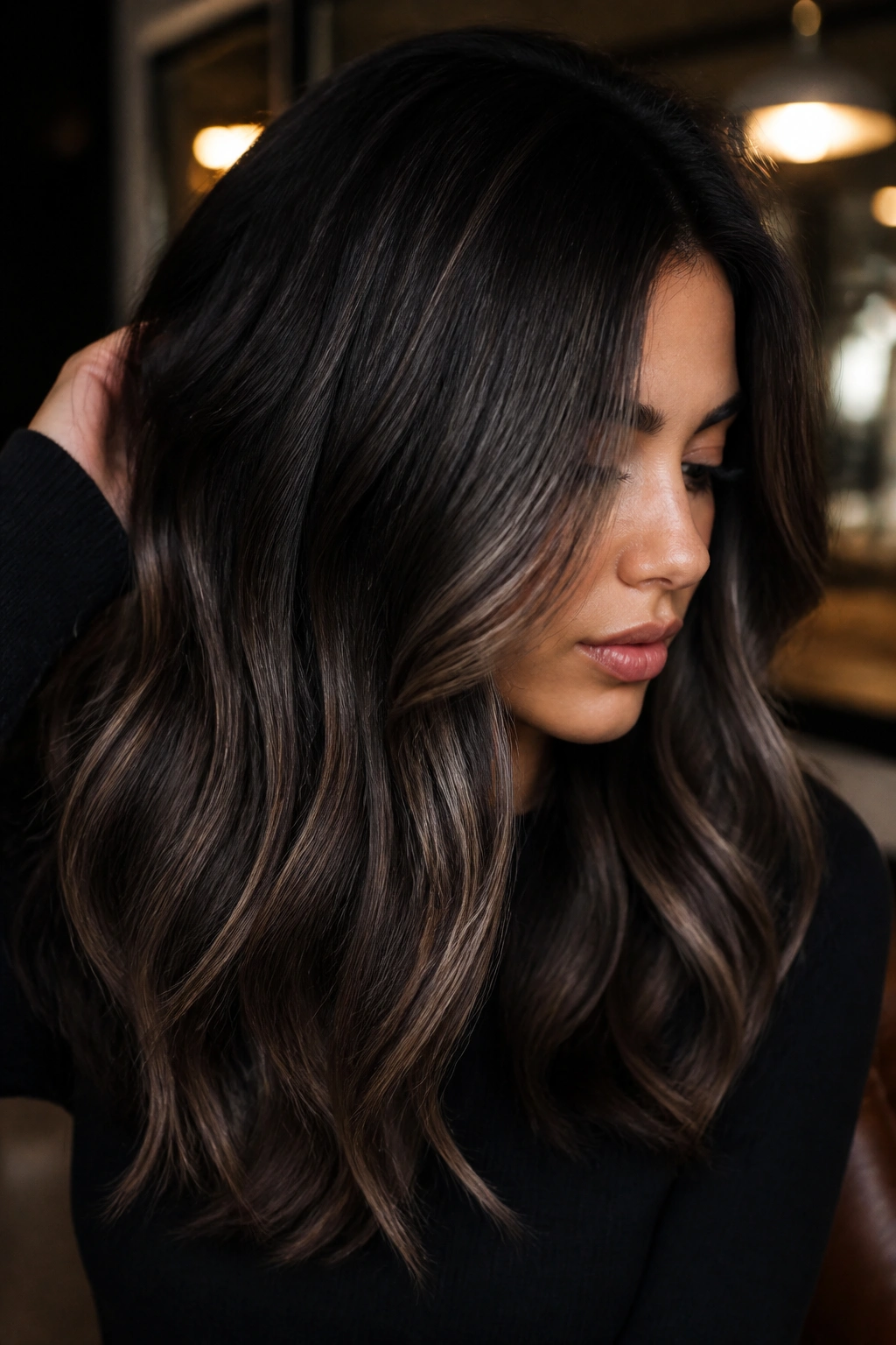 Close-up portrait of a person with smoky brunette hair in moody lighting