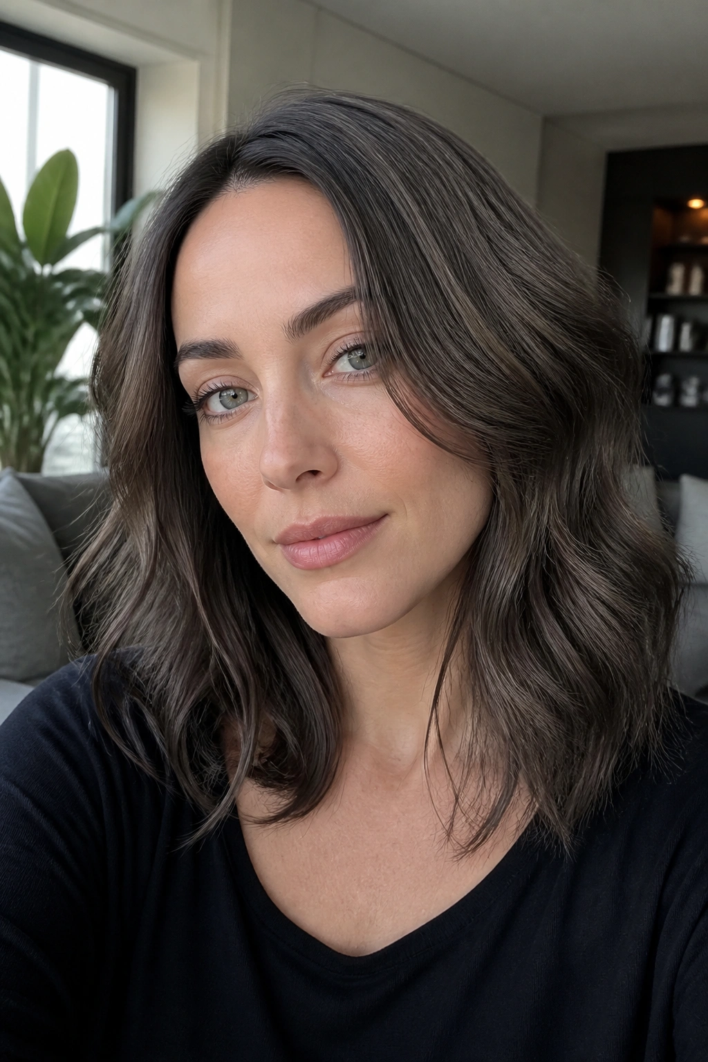 Close-up portrait of a real woman with smoky brunette hair in a sunlit living room