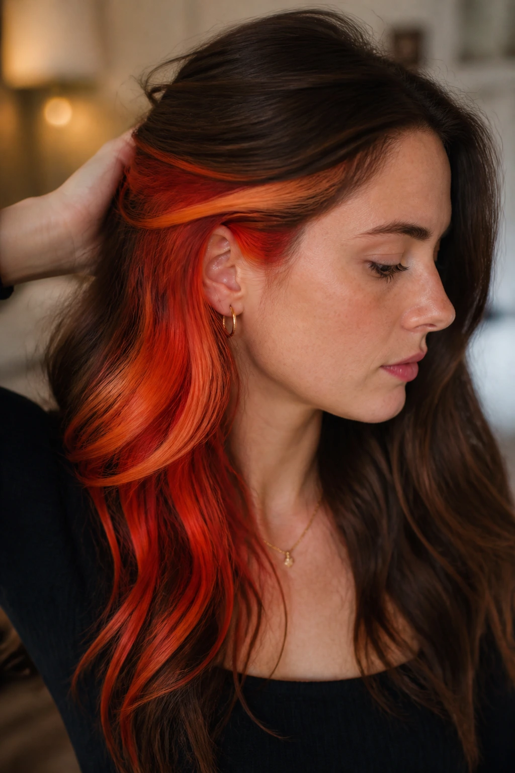 Close-up of a real person with fiery sunset orange peekaboo on brunette hair