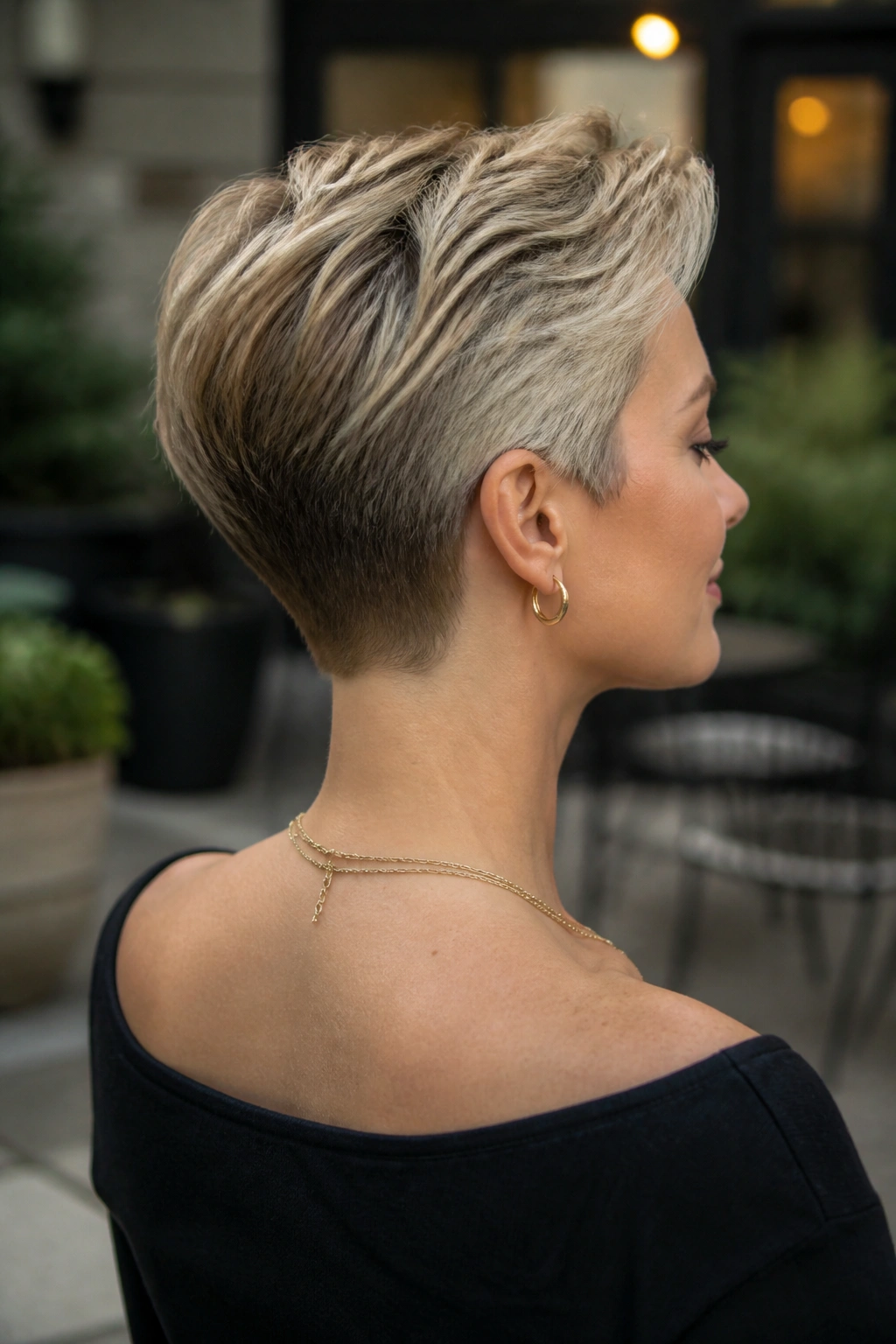 Portrait of a real woman with tapered nape pixie and clean neckline.