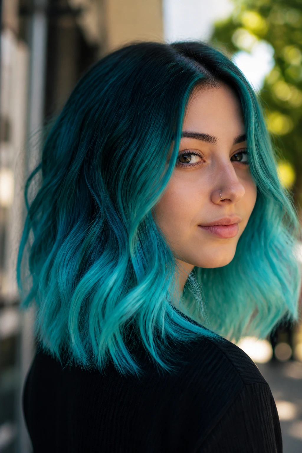 Close-up portrait of a real person with teal to turquoise ombré peekaboo hair outdoors