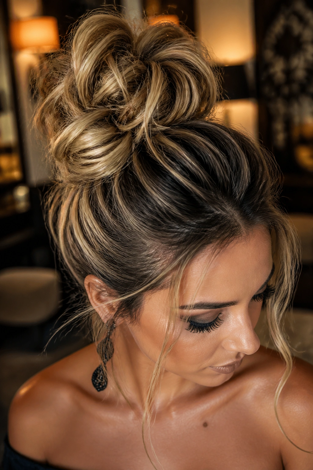 Real woman with a textured top knot and temple pieces in a warm indoor setting