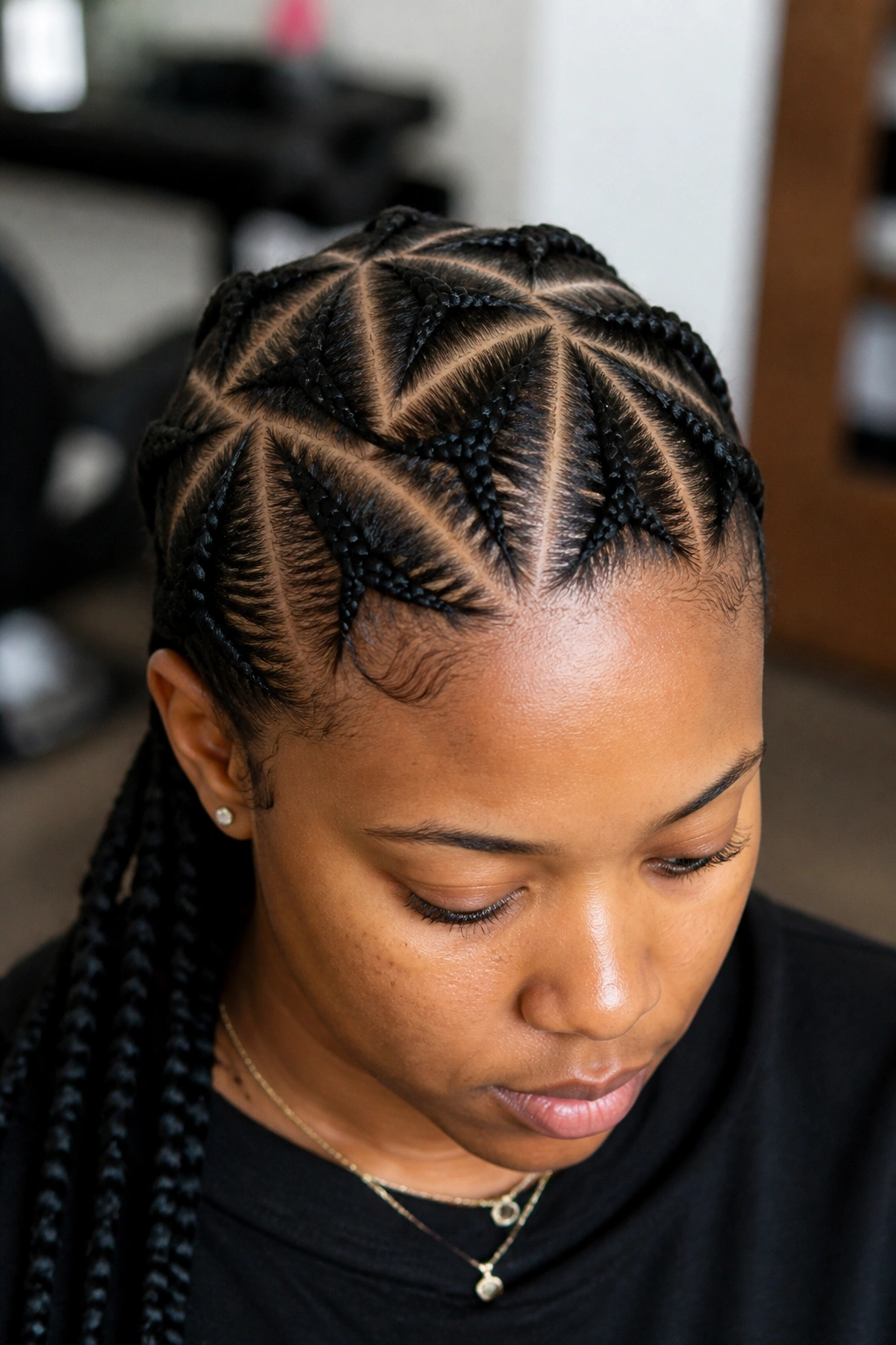 Close-up of a real woman's head showing triangle-part cornrows on the scalp