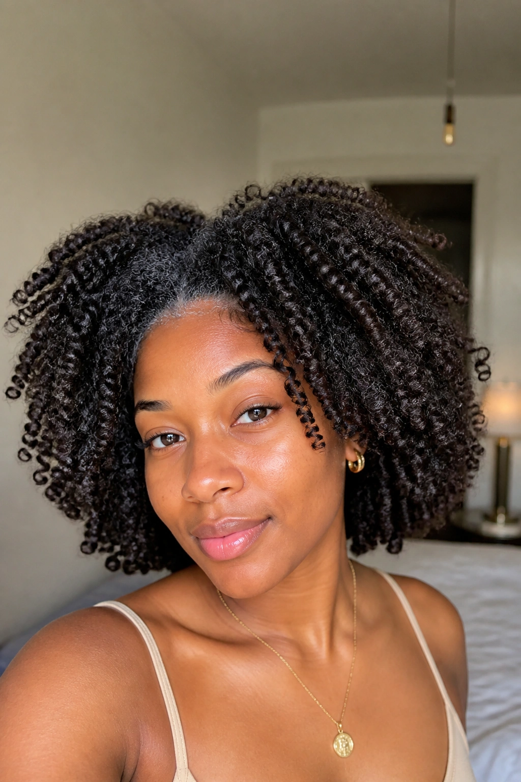 Portrait of a woman with twist-out curls and stretched roots