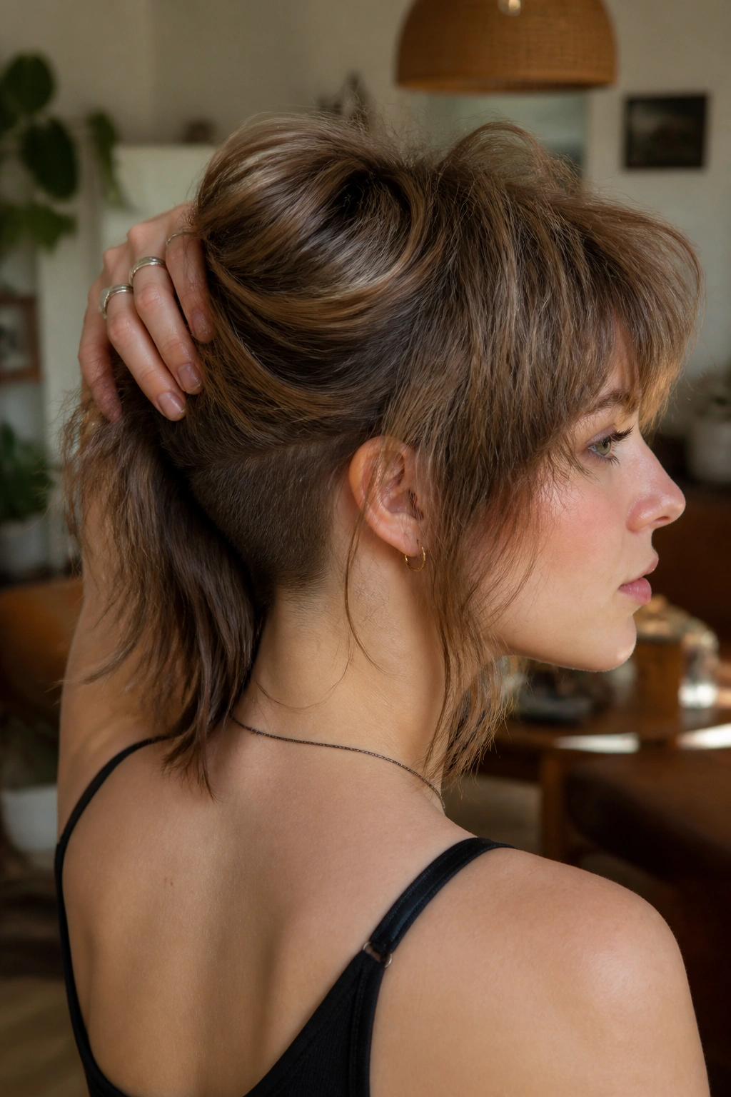 Close-up portrait of a real woman with hidden undercut shag and soft layers in warm natural light