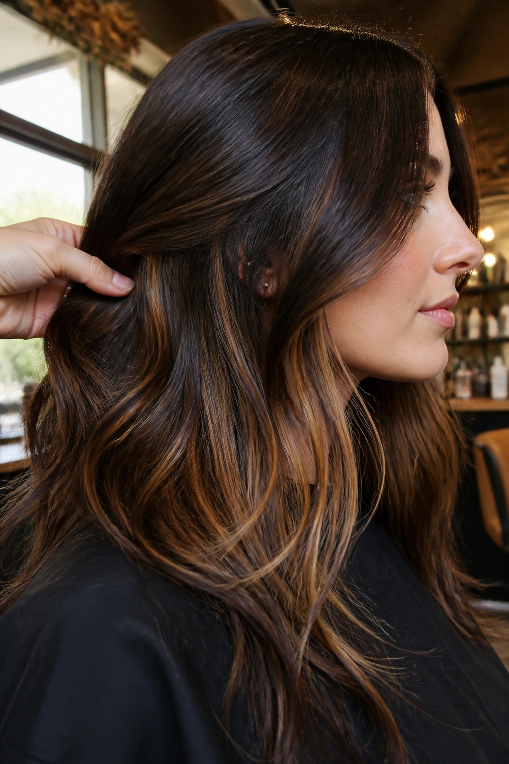Profile view showing hidden caramel underlights under dark brown hair