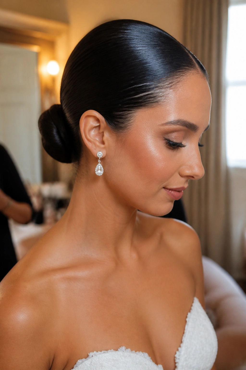 Close-up of a real bride with a wet-look slicked-back bun at the nape.