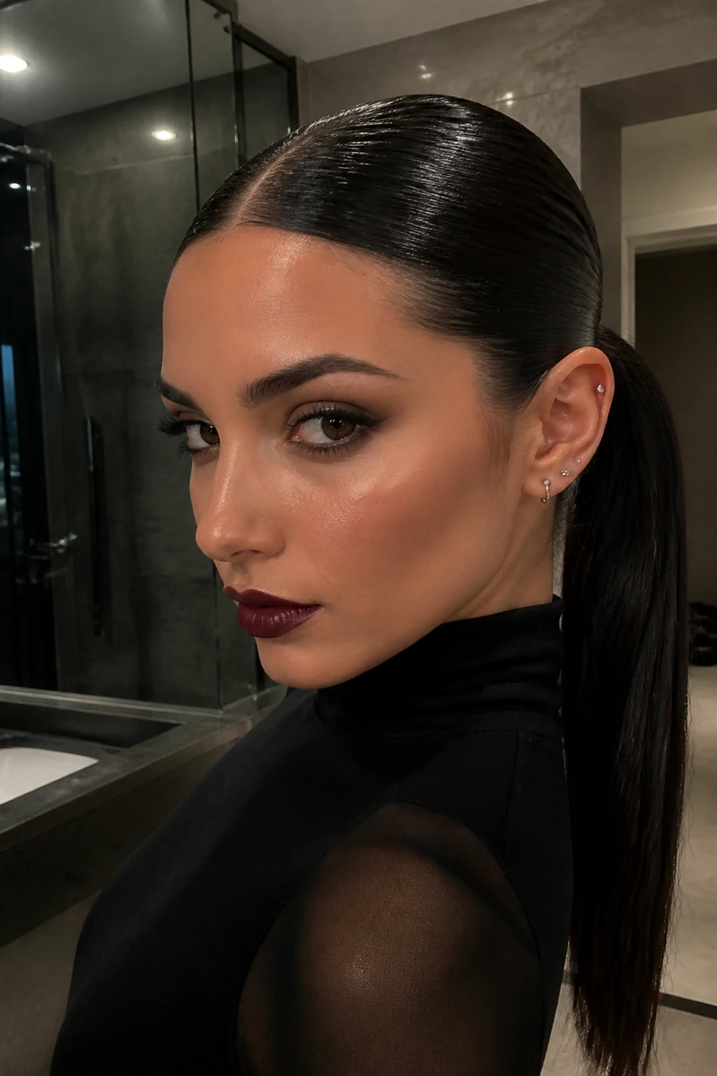 Real woman with wet-look center-part ponytail in a modern bathroom