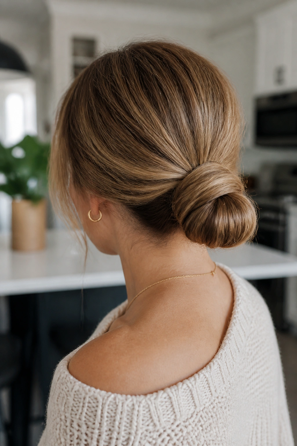 Back view of a real woman with a wrapped ponytail low bun.