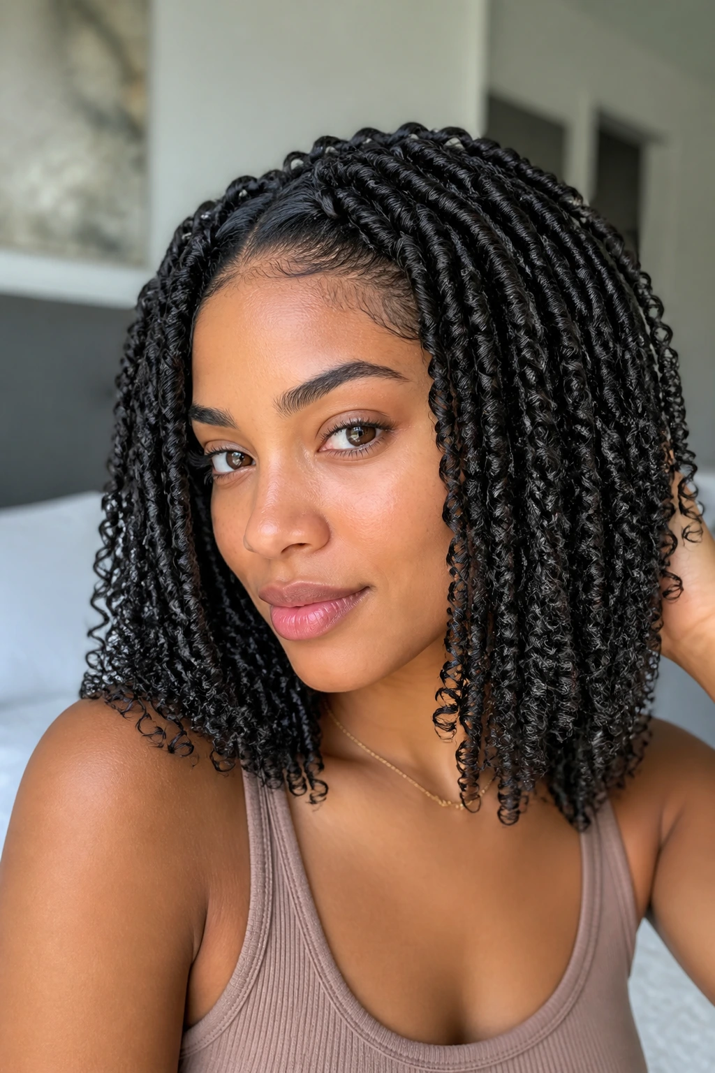 Close-up portrait of a real woman showing two-strand twists worn loose on curly hair