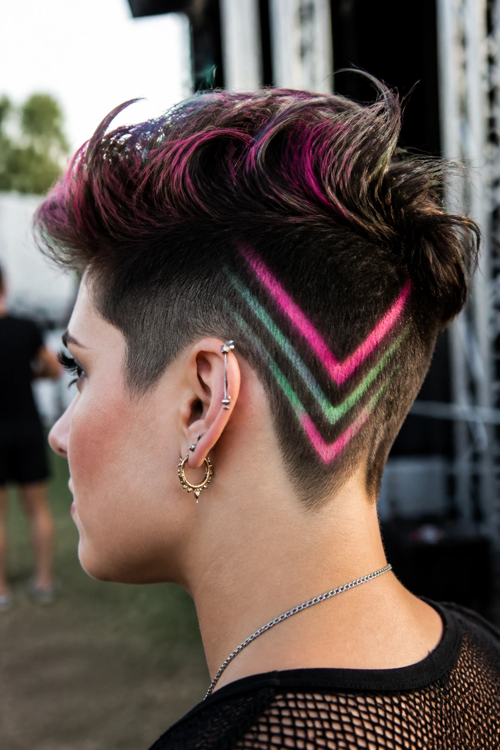 Side profile of a real person showing a sharp V-pattern chalk design on an undercut at a festival